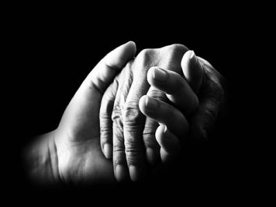 Adult hand holding child's hand.