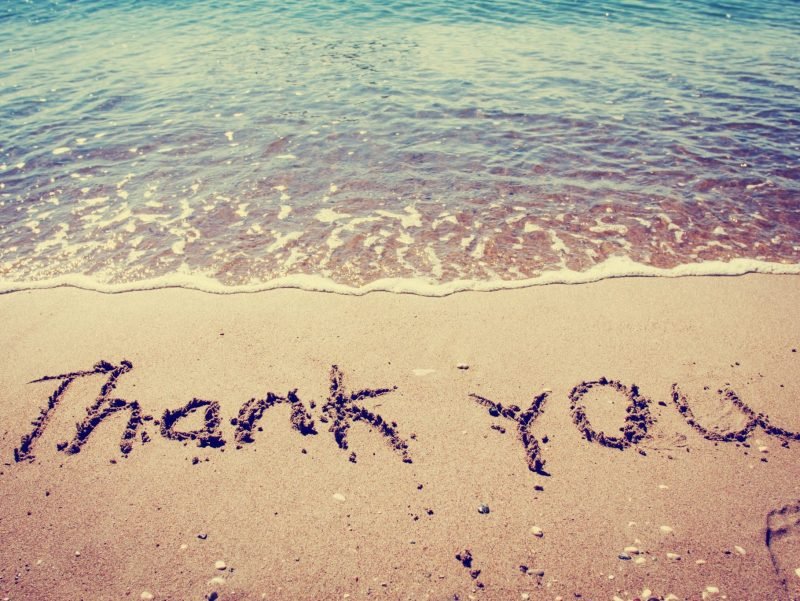 Photo of 'Thank You' written in the ocean sand.